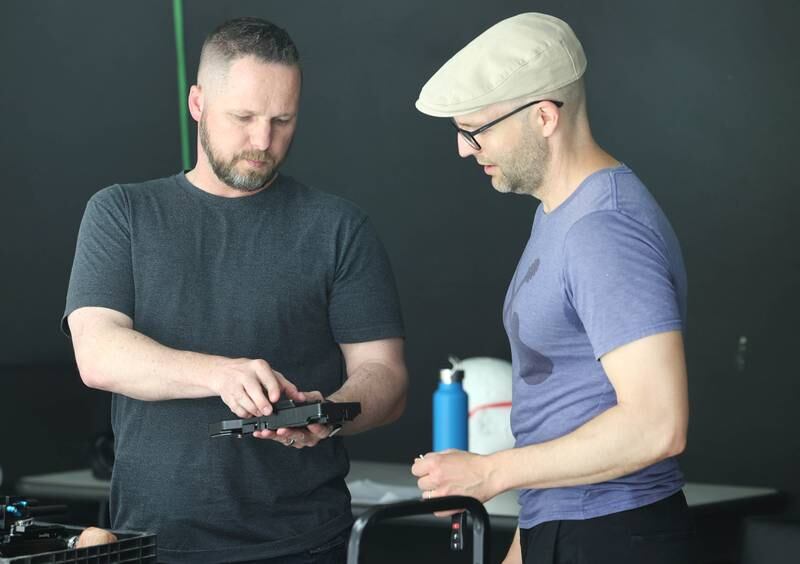 Seth Deming, with the group Write Film Edit and director for their latest project, talks to assistant Derek Hawkins about some equipment during shooting Thursday, May 16, 2024, in the studio at OC Creative in DeKalb.