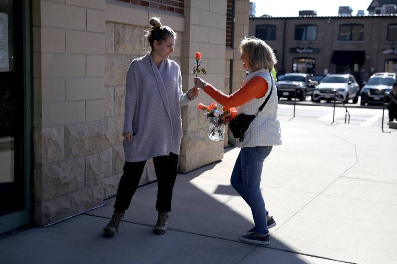 Random Acts Matter volunteer Sharon LeGare (right) hands an orange rose to Patricia Hagstrom in St. Charles as part of Random Acts of Kindness Week on Wednesday, Feb. 14, 2024.