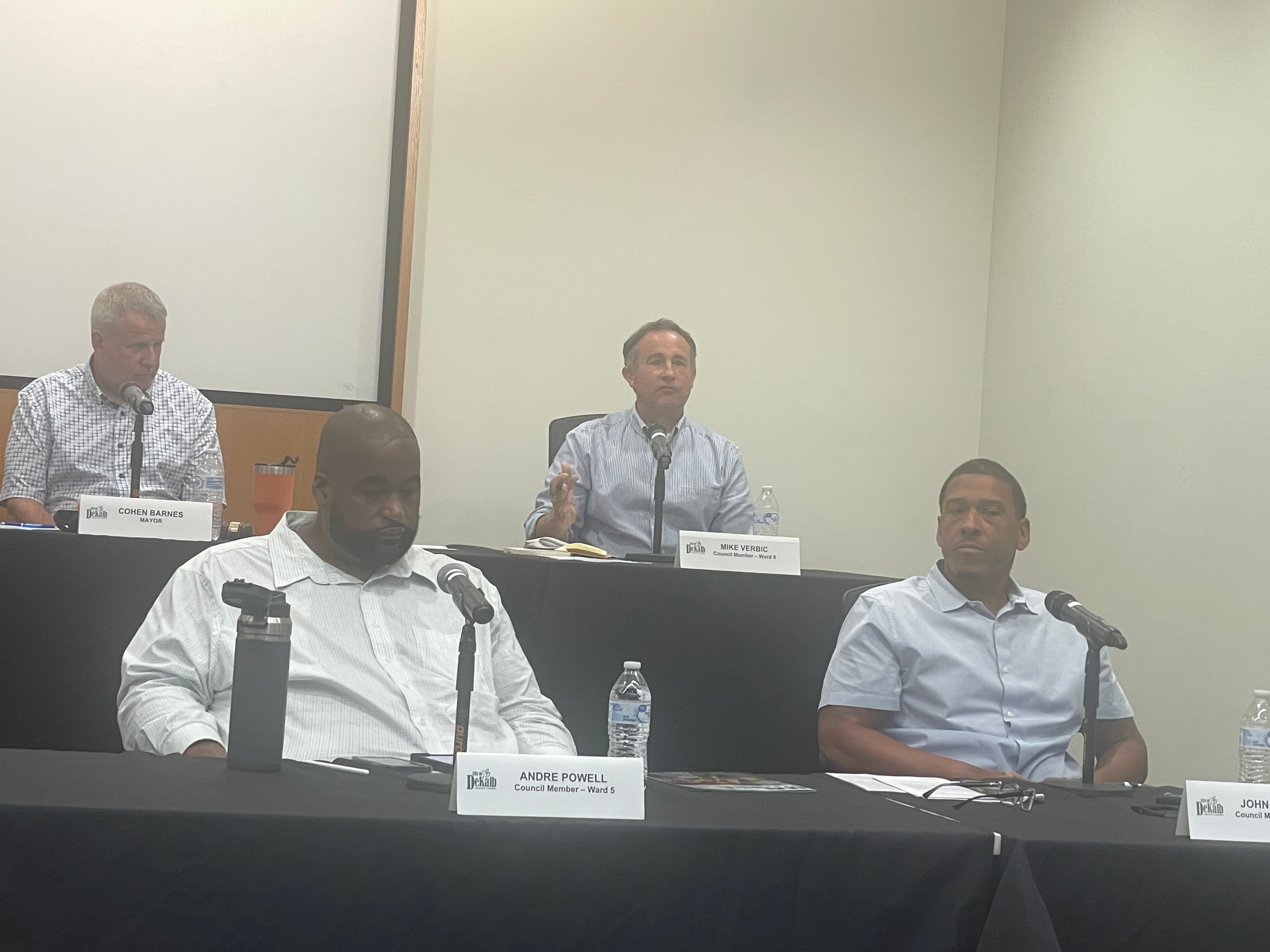 (Back left) DeKalb Mayor Cohen Barnes looks down as 6th Ward Alderman Mike Verbic speaks while (front left) 5th Ward Alderman Andre Powell and 7th Ward Alderman John Walker listen at the DeKalb City Council meeting on Monday, July 22, 2024, at the DeKalb Public Library, 309 Oak St.