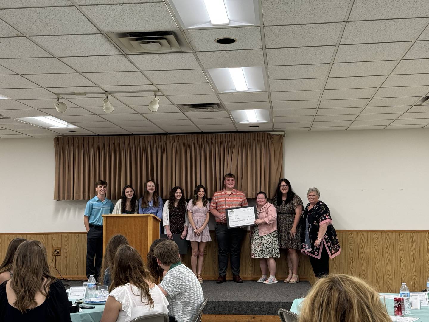Students from Coal City High School present representatives from Beans-and-Bites with a check for $1,000.