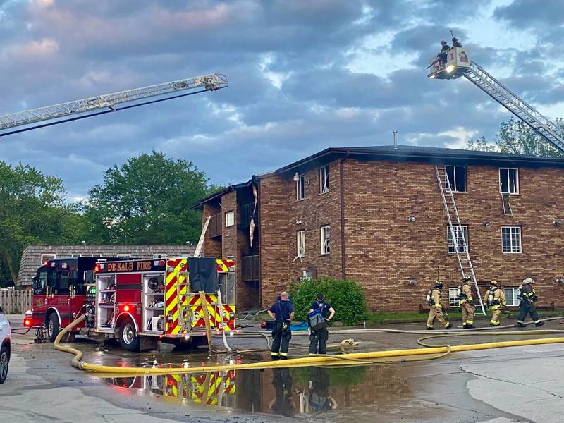 A Rochelle Fire Department ladder truck deploys its crews as DeKalb firefighters work to get a blaze under control in the rear parking lot of a Husky Ridge apartment complex in the 800 block of Kimberly Drive, DeKalb, on Wednesday evening, May 29, 2024.
