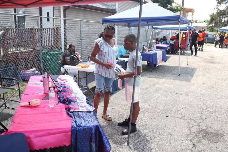 Vernita Peterson and her grandson Nolan Williamson receive free items at one of the organization tents at the Healing the Hood event held at the St. Mark CME Church in Joliet on Saturday June 29, 2024.