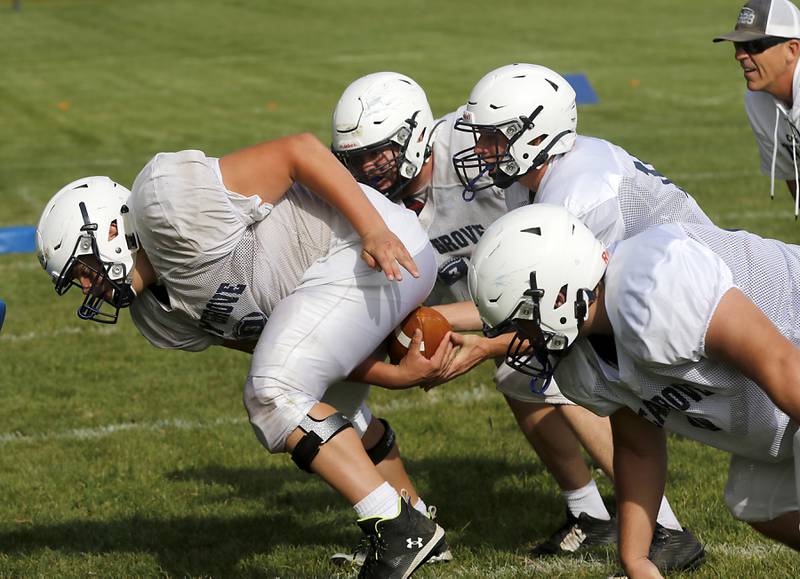 Center Lucas Burton snaps the ball to quarterback Peyton Seaburg during football practice Tuesday, Aug. 20, 2024, at Cary-Grove High School, as the 2023 IHSA Class 6A champions look to defend their title.