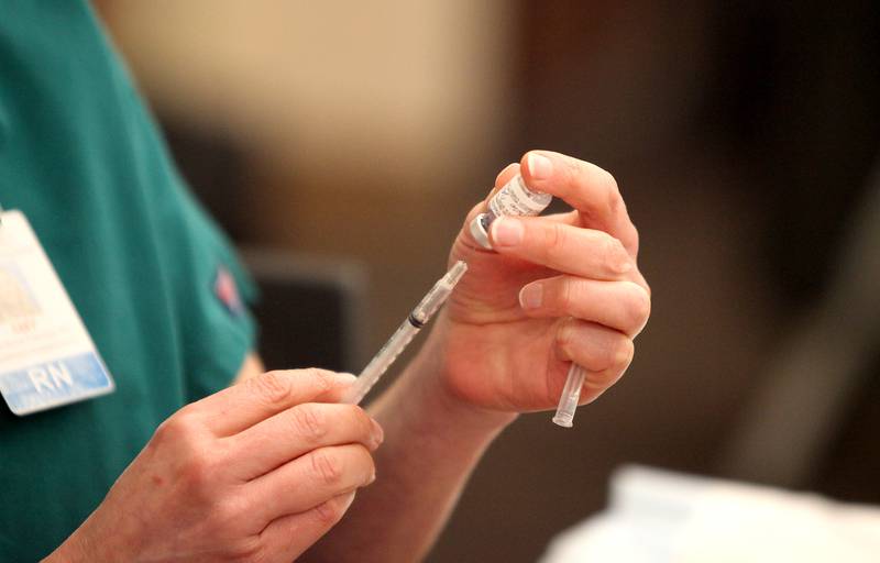 Registered Nurse Amy Rowe loads a syringe with the Pfizer COVID-19 vaccine during the first day of vaccinations for employees at Edward Hospital in Naperville on Dec. 17.