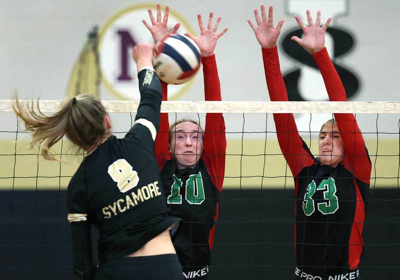 LaSalle-Peru's Katie Sowers (left) and Kelsey Frederick try to block Sycamore's Ava Carpenter during their match Tuesday, Oct. 10, 2023, at Sycamore High School.