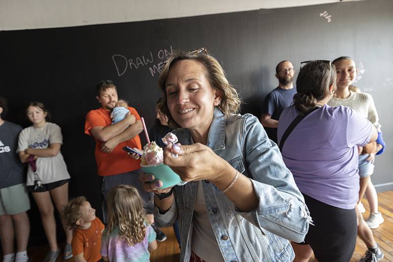 Amber Schmidt, a self-proclaimed ice cream addict, digs into a roll Monday, July 1, 2024, for the soft opening of “On A Roll” in downtown Dixon. The creamy treat is formed and rolled on a cold plate with your choice of toppings.
