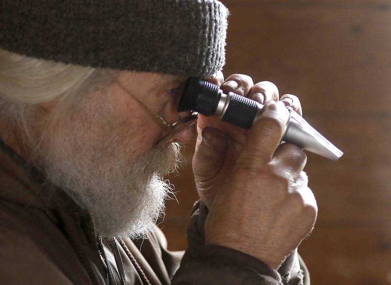 Chuck Howenstine checks to see if his maple syrup is done cooking on Thursday, March 9, 2023, at the Pioneer Tree Farm in McHenry. He has been collecting sap for most of his adult life to make maple syrup that he gives away.