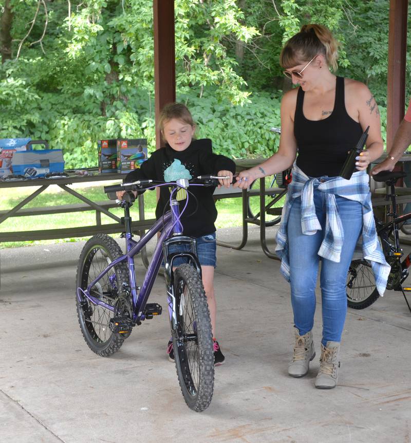 Autumn Hester, 7,, of Prophetstown, wheels out the new bike she chose at the 18th annual Dick Brown Fishing Derby at Prophetstown State Park on Saturday, June 15, 2024.