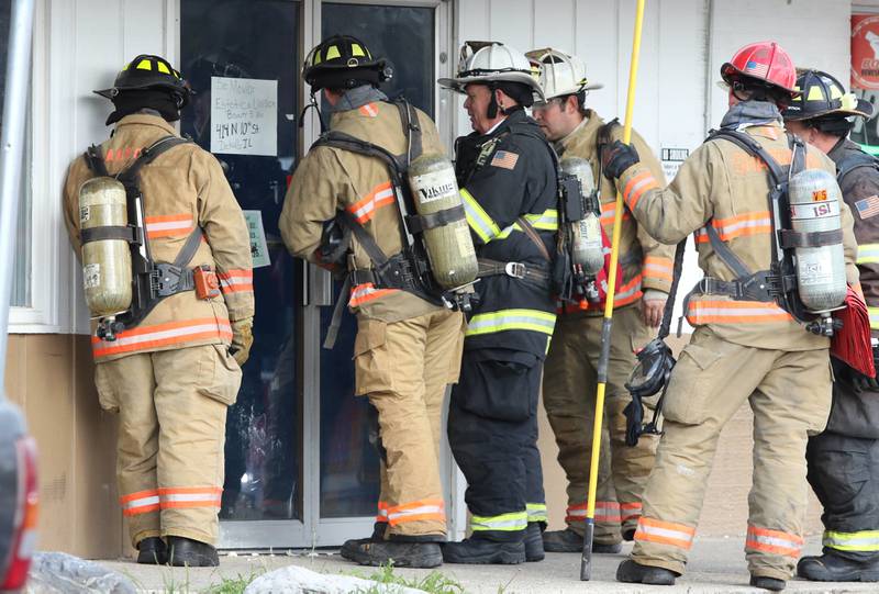 Firefighters from multiple departments work to gain entry into one of the units in the Hunter Hillcrest property at 1019 West Hillcrest Drive in DeKalb Wednesday, Nov. 3, 2021, after a fire in one of the apartments in the building.