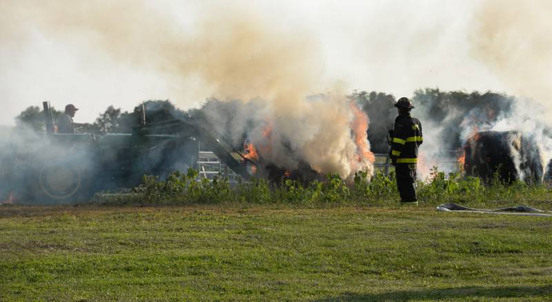 Lyle Hopkins of rural Polo uses a John Deere tractor to move a burning round bale of hay out of a burning machine shed owned by his neighbor, Herschel Newcomer, at 7015 W. Judson Road, southeast of Polo Monday evening, Sept. 10, 2024. Several fire departments assisted the Polo Fire Department on the call. There were no injuries.