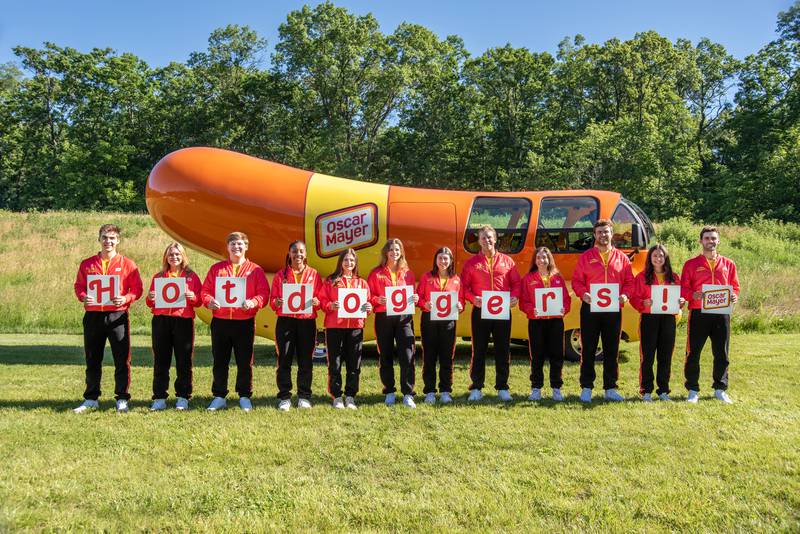 Hotdoggers stage themselves along the Oscar Mayer Wienermobile, which will visit several Sullivan's grocery stores in northern Illinois next week.