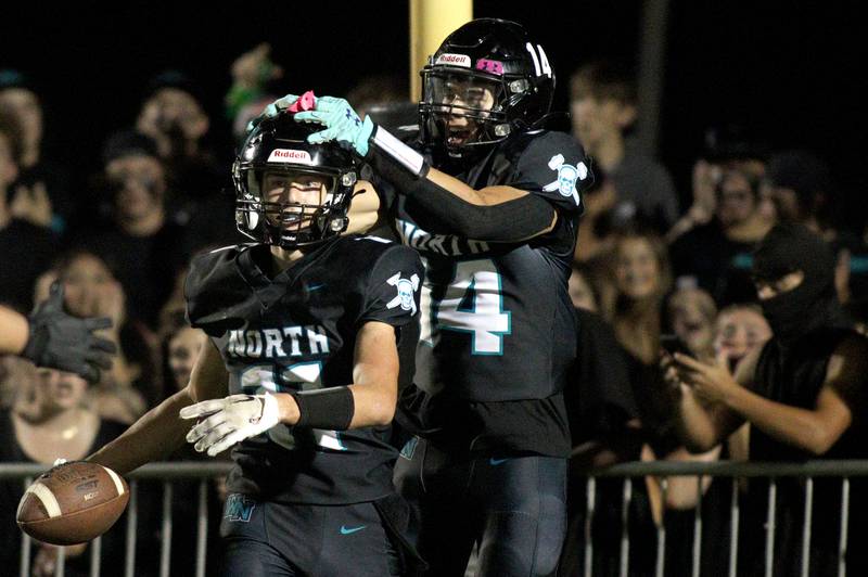 greeted by Dillon Morrison after scoring a touchdown against Woodstock in varsity football at Woodstock North Friday night.