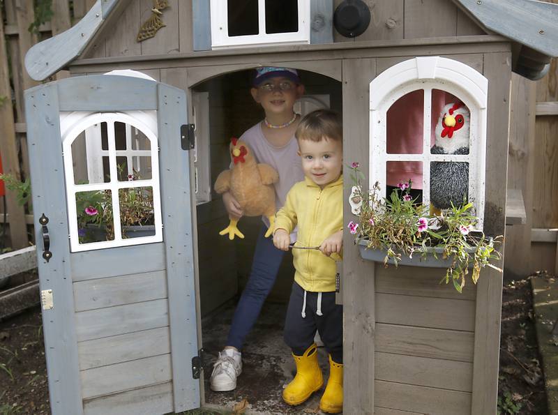 Myles Helmeid and his sister, Emmaline, in the playhouse that would make a great chicken coop on Tuesday, Sept. 26, 2023. Their mother Harvard resident Jessica Helmeid is circulating a petition asking the city to allow backyard chickens.