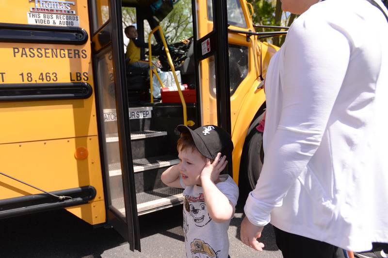 Lucas Dunne of Brookfield reacts to the loud horn of a school bus during the La Grange Park District's Touch A Truck event held at Sedgwick Park Saturday May 11, 2024.