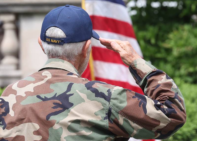 A U.S. Navy veteran salutes the flag Monday, May 27, 2024, during the playing of "Anchors Aweigh" at the DeKalb Memorial Day program at Ellwood House.