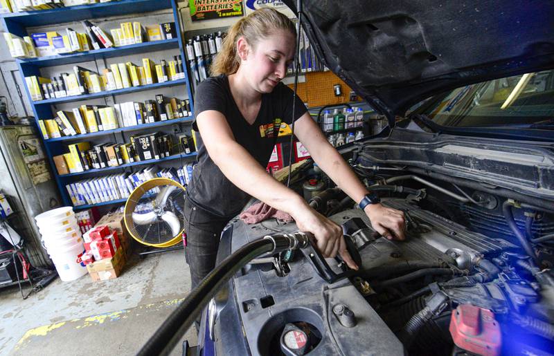 FILE - Elise Lacroix, owner of Stop & Go in Brattleboro, Vt., changes the oil on a vehicle at her shop on July 15, 2024. (Kristopher Radder/The Brattleboro Reformer via AP, File)