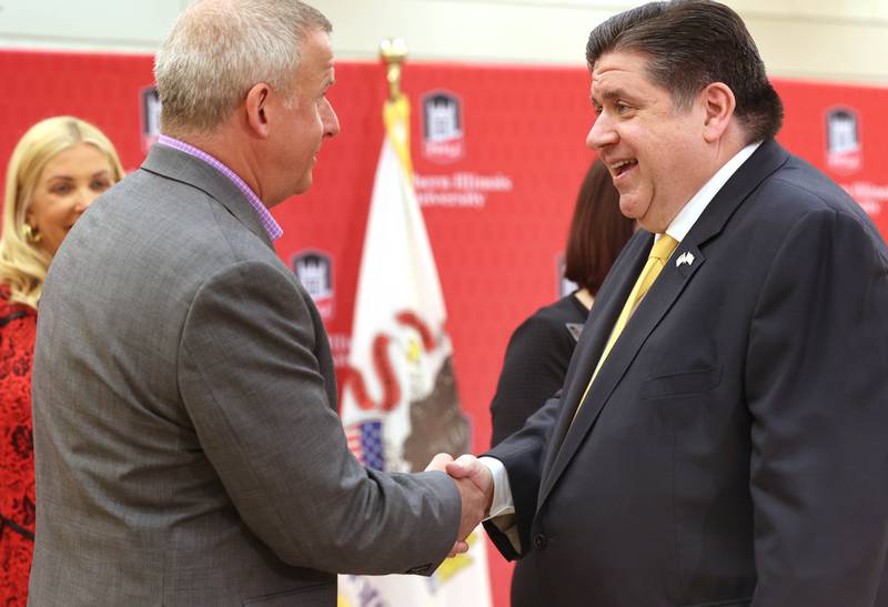 DeKalb Mayor Cohen Barnes (left) greets Gov. JB Pritzker during a news conference Tuesday, April, 4, 2023, in the Barsema Alumni and Visitors Center at Northern Illinois University in DeKalb. Pritzker along with a group of llinois lawmakers, DeKalb city officials and representatives from NIU were on hand to promote the importance of funding higher education in Illinois.