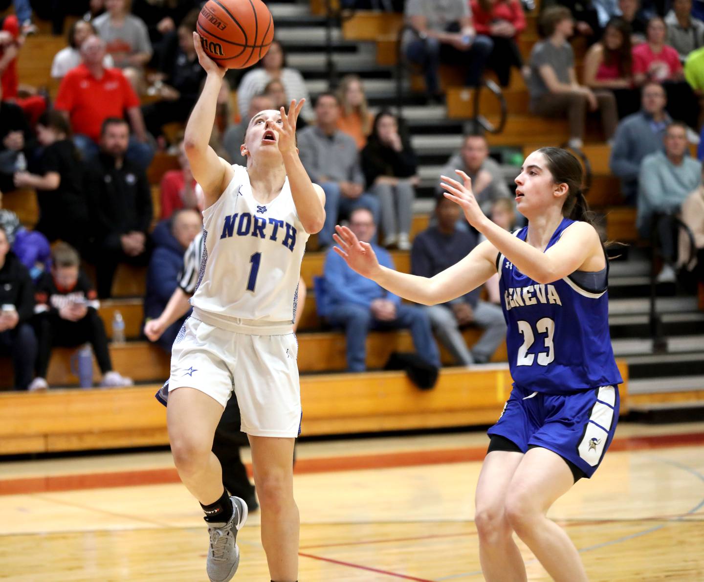 St. Charles North’s Laney Stark gets the ball to the basket away from Geneva’s Lucie Garnier during a Class 4A Batavia Sectional semifinal game on Tuesday, Feb. 20, 2024.