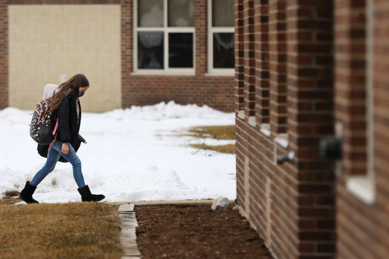 A student heads into school during the first day back to hybrid learning in Huntley Community School District 158, incorporating a split between remote and in-person learning, on Monday, Jan. 25, 2021, at Leggee Elementary School in Huntley.