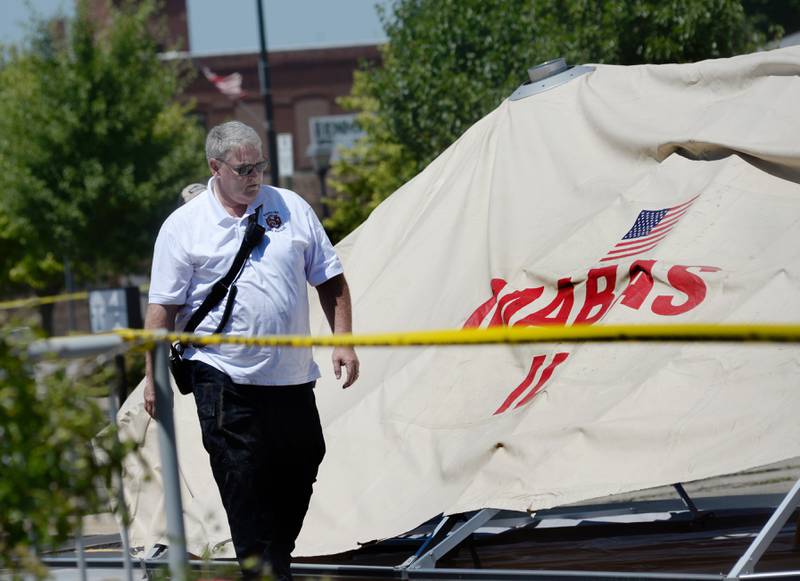 A Sterling fire department official watches on Monday, July 10, 2023, as a large Mutual Aid Box Alarm System (MABAS) tent was raised in the Wipfli parking lot across from the charred apartment building at 406 E. Third St.