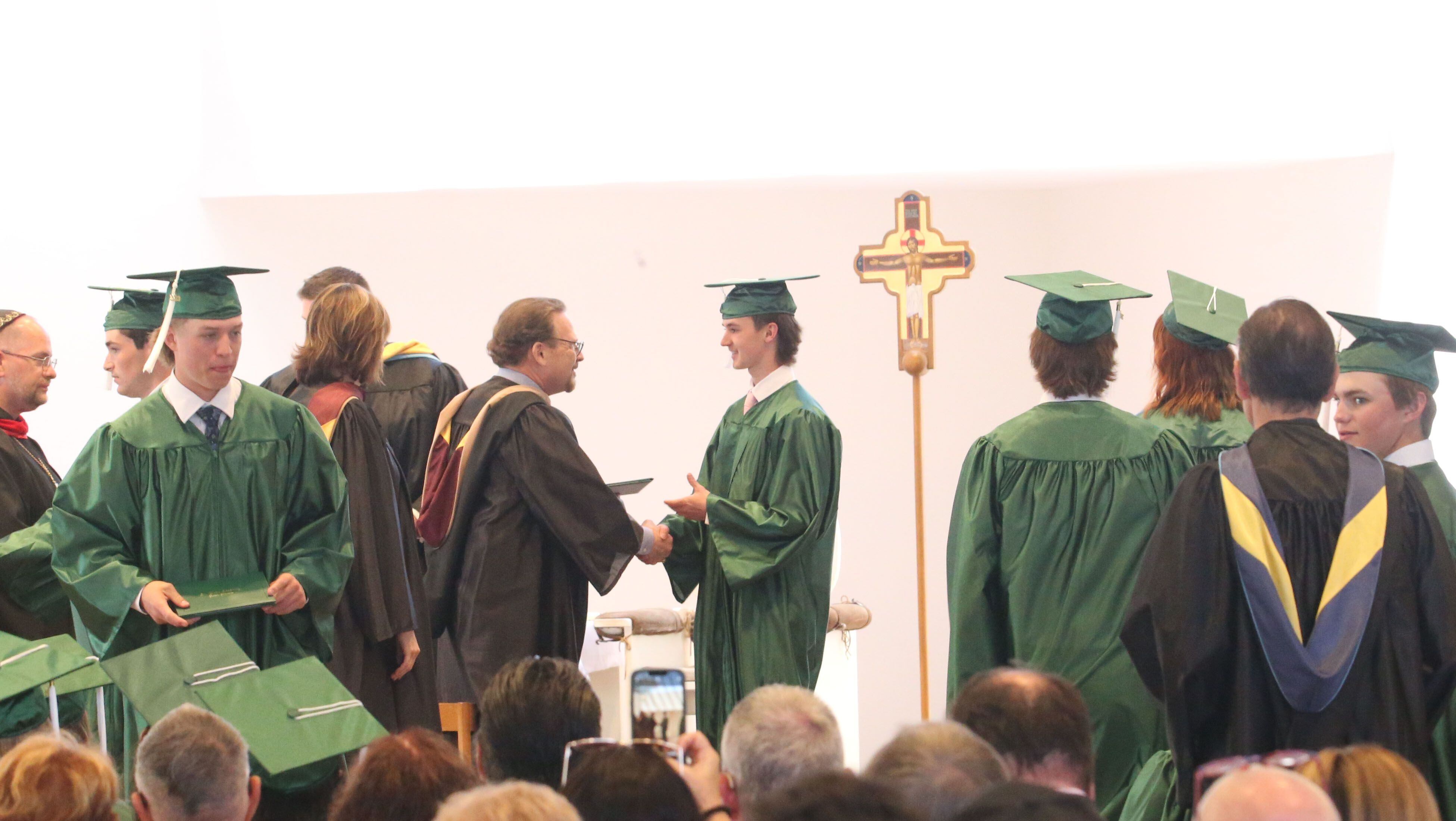 St. Bede graduates receive their diplomas during the Class of 2023 graduation ceremony on Sunday, May 21, 2023, in the Abbey Church at the academy.