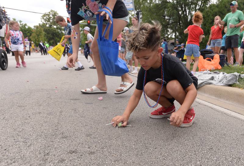 Giovanni McPherson of Downers Grove gets some candy during the Downers Grove Fourth of July Parade on Thursday, July 4, 2024.