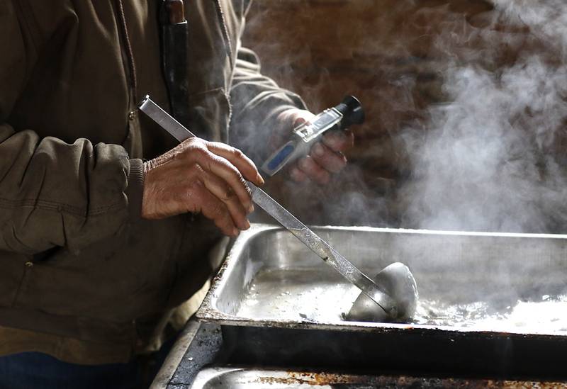 Chuck Howenstine gives the maple syrup a stir before checking to see if it is done cooking on Thursday, March 9, 2023, at the Pioneer Tree Farm near McHenry. He has been collecting sap for most of his adult life to make maple syrup that he gives away.