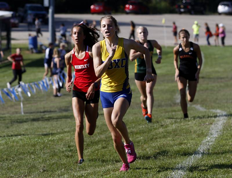 Johnsburg’s Jolene Cashmore out springs Huntley’s Brittney Burak during the boys/girls race of the McHenry County Cross Country Meet Saturday, August 27, 2022, at Emricson Park in Woodstock.