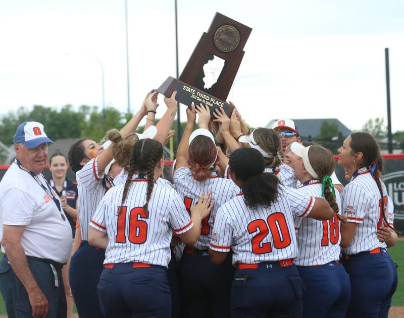 Members of the Oswego softball team hoist the Class 4A third place trophy on Saturday, June 8, 2024 at the Louisville Slugger Sports Complex in Peoria.