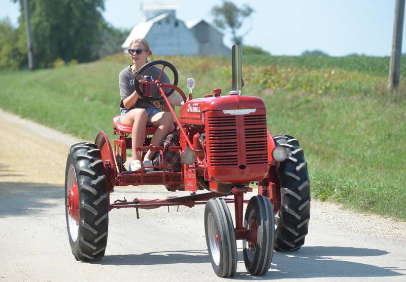 Izabella Cater, 15, of Dixon, drives her grandparents' 1947 Farmall "B" tractor during the Living History Antique Equipment Association's tractor drive on Saturday. About 40 tractors took part in the ride that started at the association's show grounds in Franklin Grove and traveled to Oregon and back.