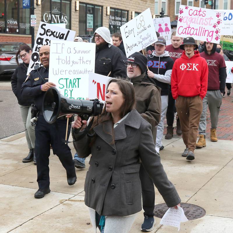 Kelsey Gettle, Safe Passage legal program manager, leads marchers in a chant Tuesday, April 2, 2024, near the Egyptian Theatre, during Take Back the Night in DeKalb. The event, hosted by Safe Passage, is in honor of Sexual Assault Awareness Month and featured speakers and a march.