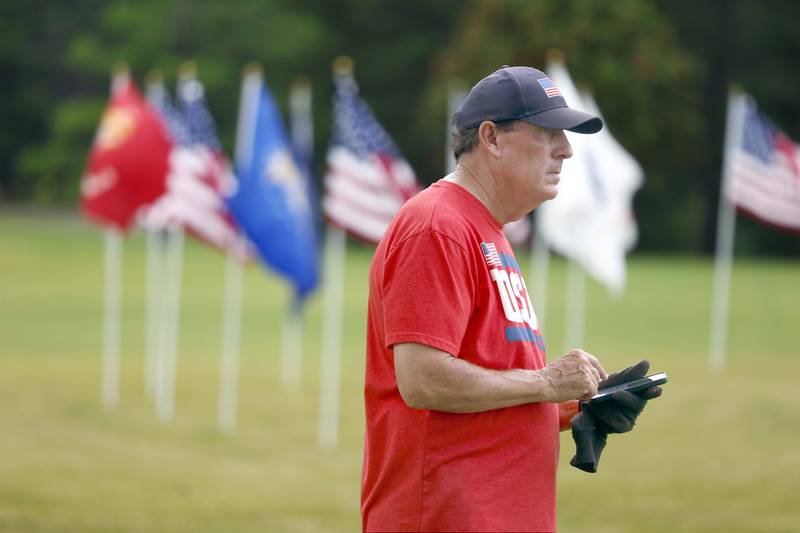 Rudy Keller looks at his notes as he oversees the set up for the Field of Honor, a display of 2,024 American flags arranged in 25 neat rows Saturday, June 29, 2024 at Seven Gables Park in Wheaton. Keller has been putting up flag installations around DuPage County for years.