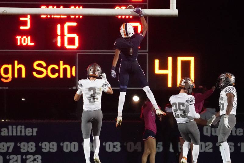 Oswego’s Jeremiah Cain (1) dunks the ball over the uprights after scoring a touchdown against Minooka during a football game at Oswego High School on Friday, October 18, 2024.