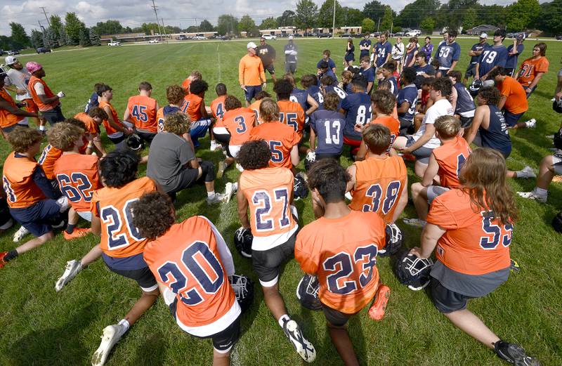 Oswego players gather around their head coach Brian Cooney after football practice at Oswego High School on Monday, Aug 7, 2023.