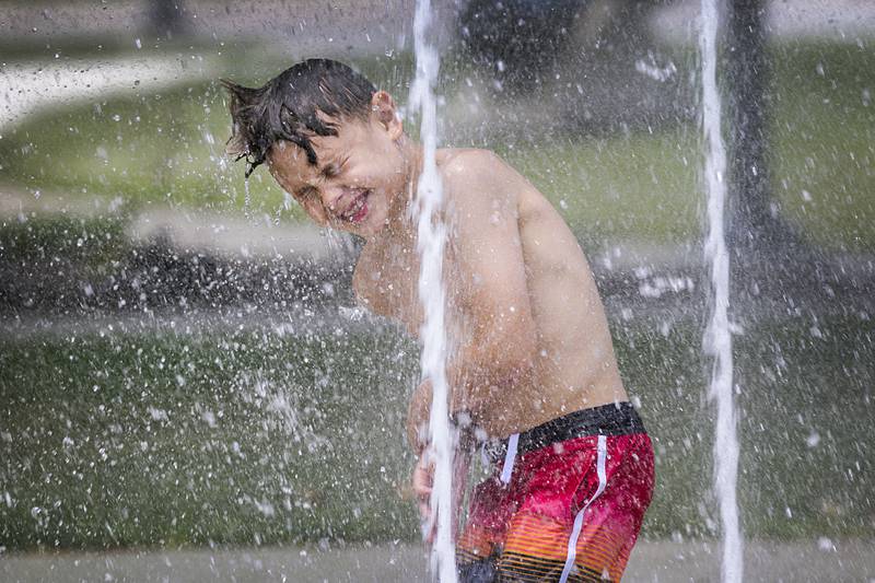 Eli Olalde, 8, of Fulton splashes through the fountain Thursday, June 20, 2024 at Grandon Park in Sterling. It was another great day to find a cool spot or take a dip as temps again stayed in the 90’s.