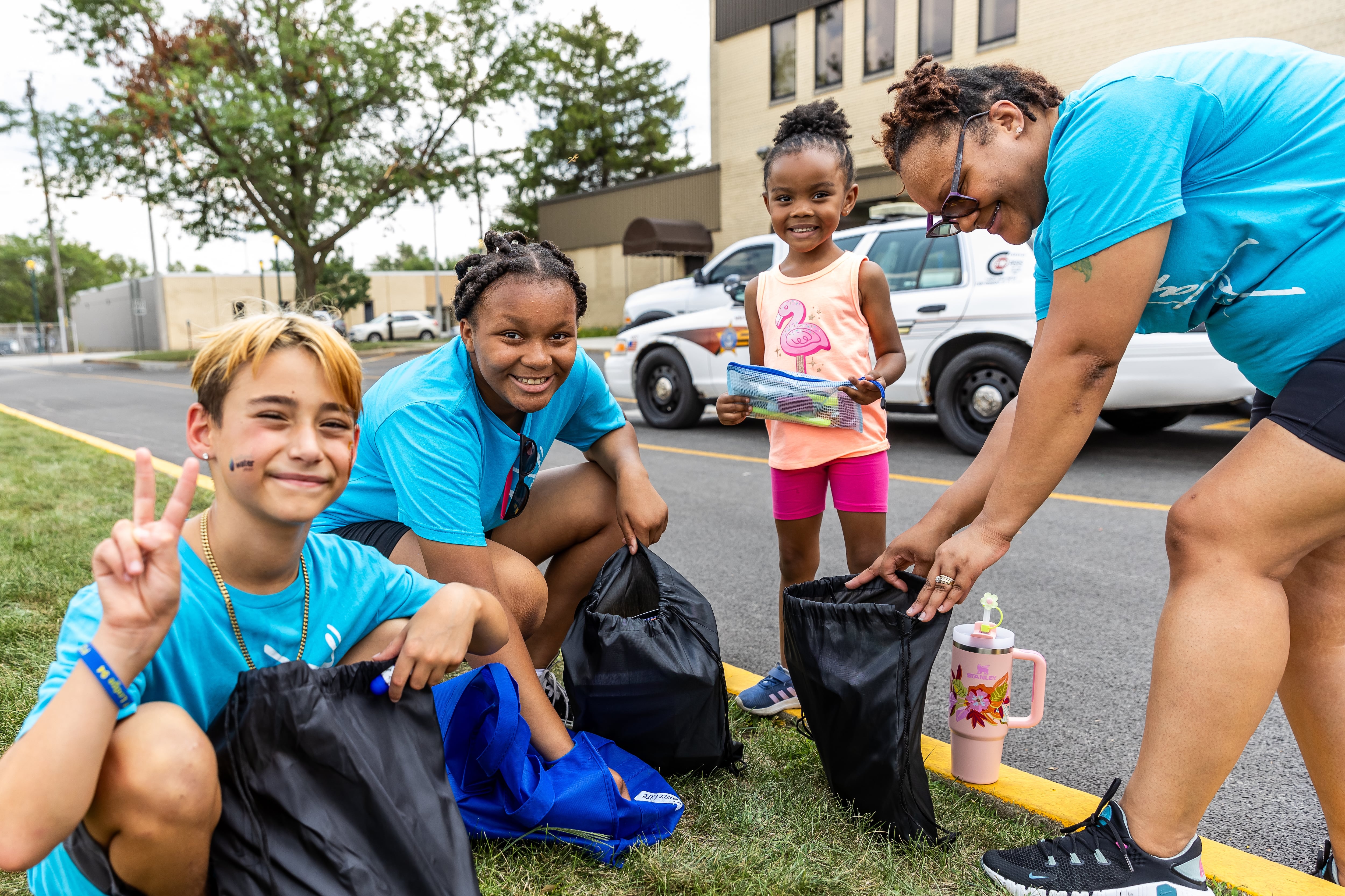 Joliet residents Rocco Borelli (9), Hailey Jeffers (11), Ashanti Harris (4), and Michelle Harris check-out the school supplies giveaways at Kidz Fest in Joliet on Aug. 3, 2024.