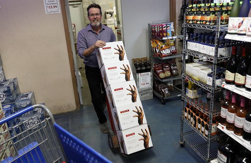 Store manager Brian Batridge wheels in cases of retired Chicago Bulls star Scottie Pippen’s Digits bourbon after the store was able to get some more deliver while Pippen was signing them on Thursday, Feb. 9, 2023, at The International House of Wine and Cheese, at 11302 Route 12, in Richmond.