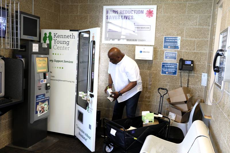 Daryl Pass, manager of Recovery Support Services for the Kenneth Young Center, fills the free narcan vending machine in the lobby of the Kane County Sheriff’s office in St. Charles. The center gets narcan free from the state overdose prevention program.