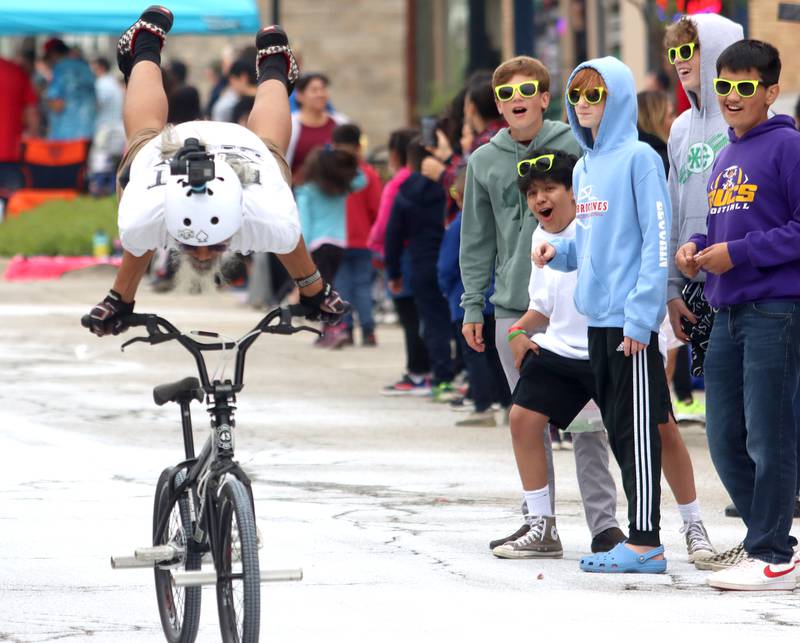 Kids react as a stunt rider from Flat 43 BMX passes during the Harvard Milk Days parade Saturday, June 4, 2022, in Harvard.