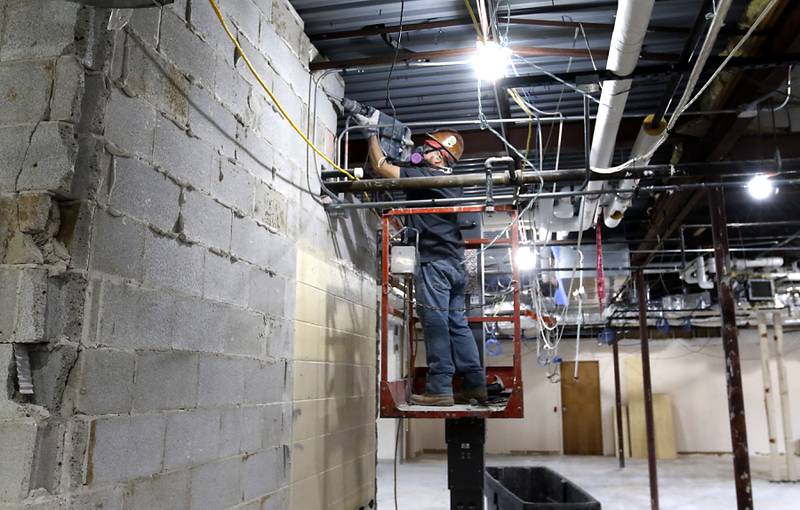 A construction worker removes a piece of a wall Tuesday, Feb. 7, 2023, at the old Cary Village Hall, at 655 Village Hall Drive in Cary. Work has started on converting the space into the McHenry County Sheriff's Office's new law enforcement training facility. The facility will allow local agencies to train closer to home.