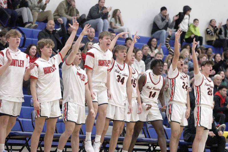 Huntley’s Red Raiders celebrate taking the lead late in a win over Crystal Lake South in varsity basketball tournament title game action at Johnsburg Friday.