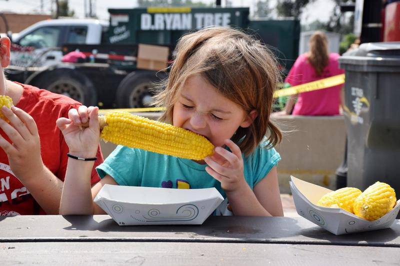 Seven-year-old Nadia Cirone of Oswego bites into an ear of sweet corn donated by Del Monte Foods in Mendota during the Chuck Siebrasse Corn Boil at Corn Fest on Aug. 25.