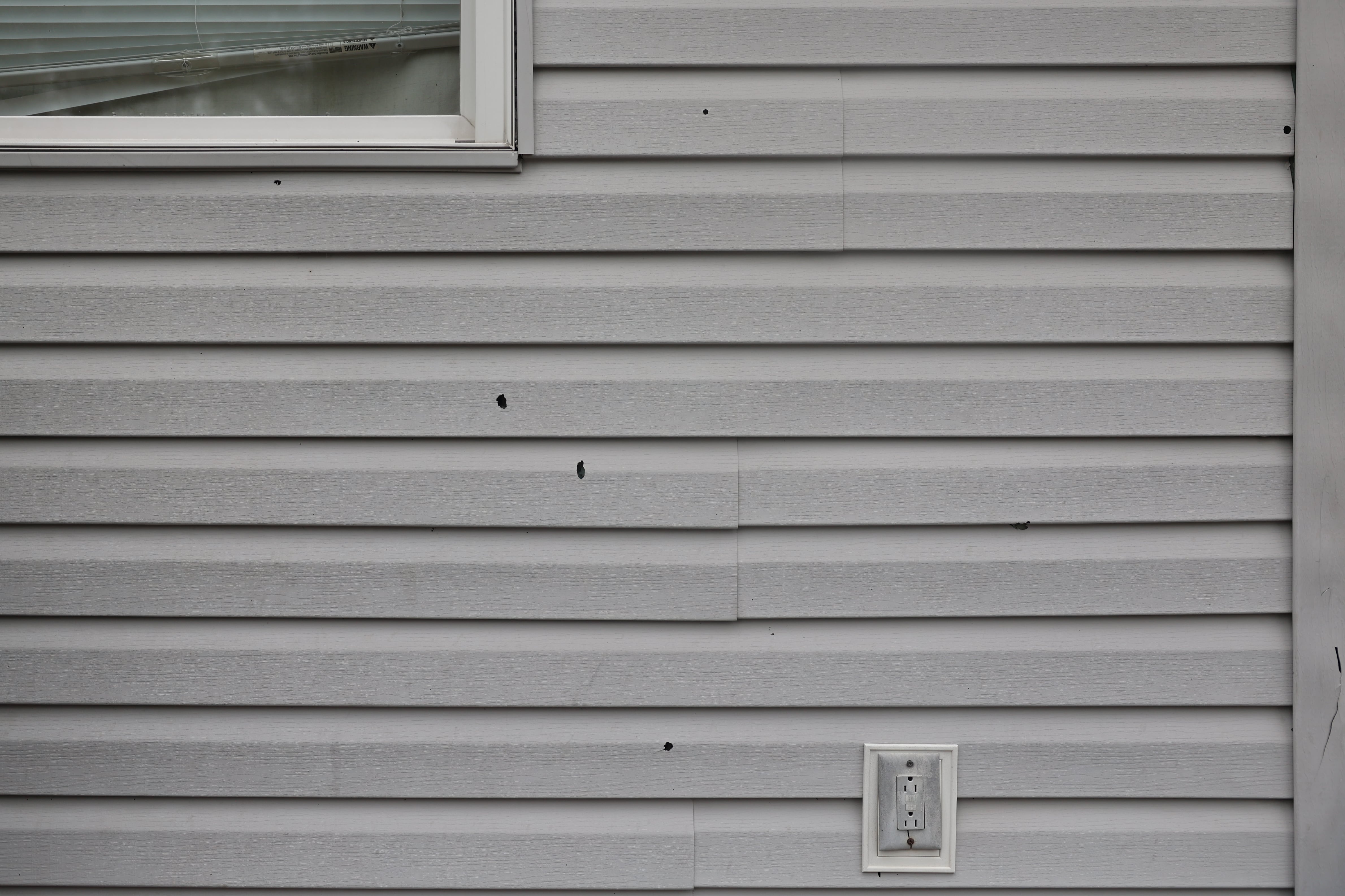 Several bullet holes are visible on the siding of a home. On Wednesday morning July, 24, 2024, Joliet Police responded to shots fired in the 1400 block of North Center Street, Joliet. No injuries were reported.