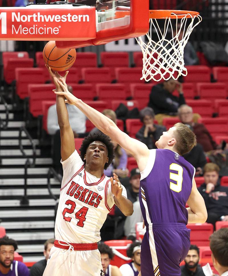 Northern Illinois Huskies guard Darweshi Hunter tries to get a shot up over Albany Great Danes forward Trey Hutcheson during their game Tuesday, Dec. 20, 2022, in the Convocation Center at NIU in DeKalb.