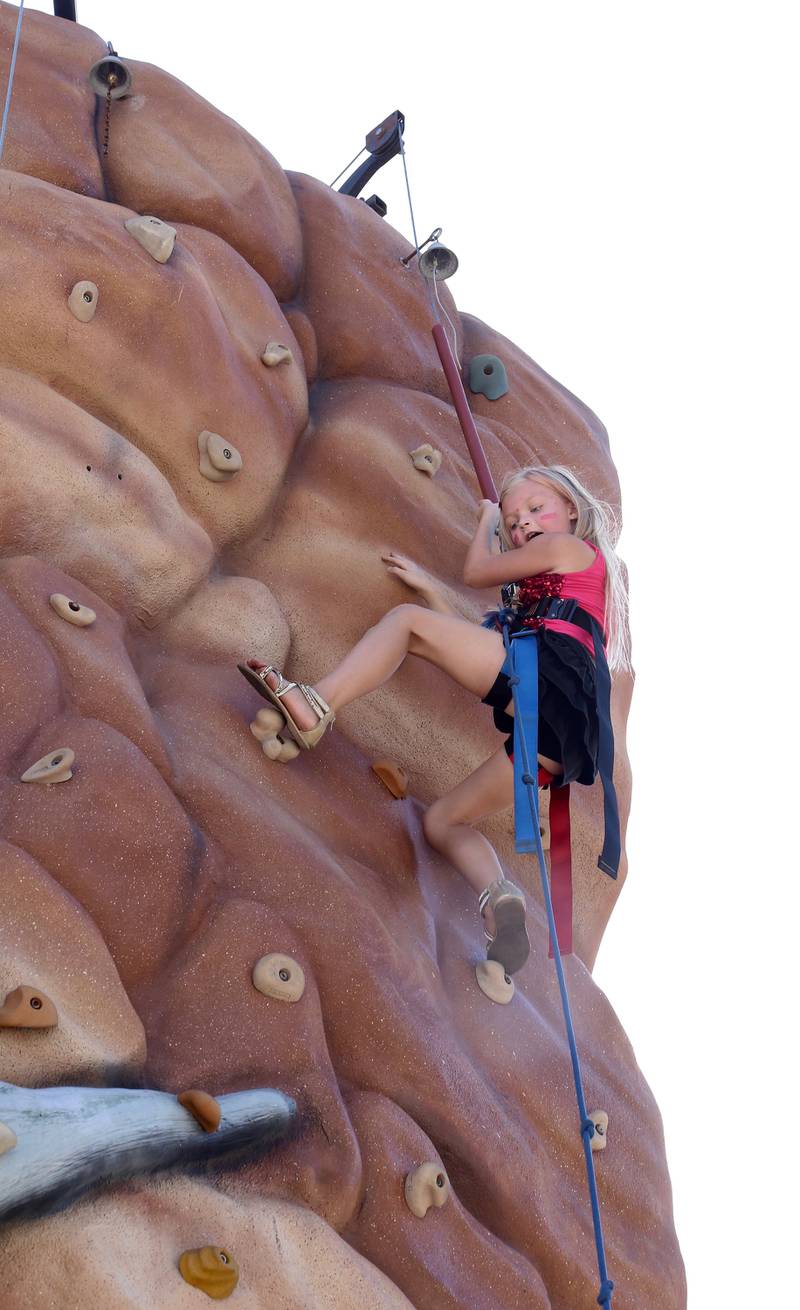 Seven-year-old Chloey Clevenger of Maple Park climbs to the top of the rock climbing structure at the Maple Park Fun Fest on Saturday, Sept. 2, 2023.