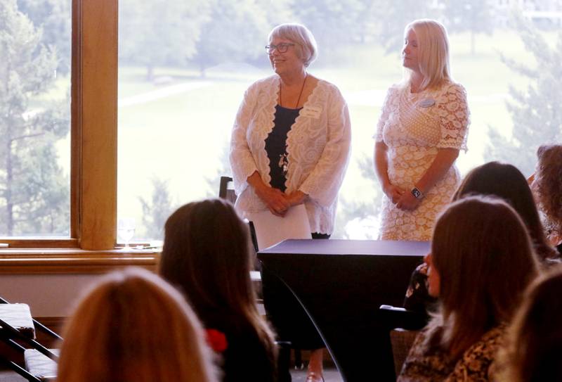 Award recipient Ellen Hanson stands with  Northwest Herald publisher Laura Shaw as Kathleen Caldwell introduces Hanson during the Northwest Herald's Women of Distinction award luncheon Wednesday June 5, 2024, at Boulder Ridge Country Club, in Lake in the Hills. The luncheon recognized 11 women in the community as Women of Distinction.