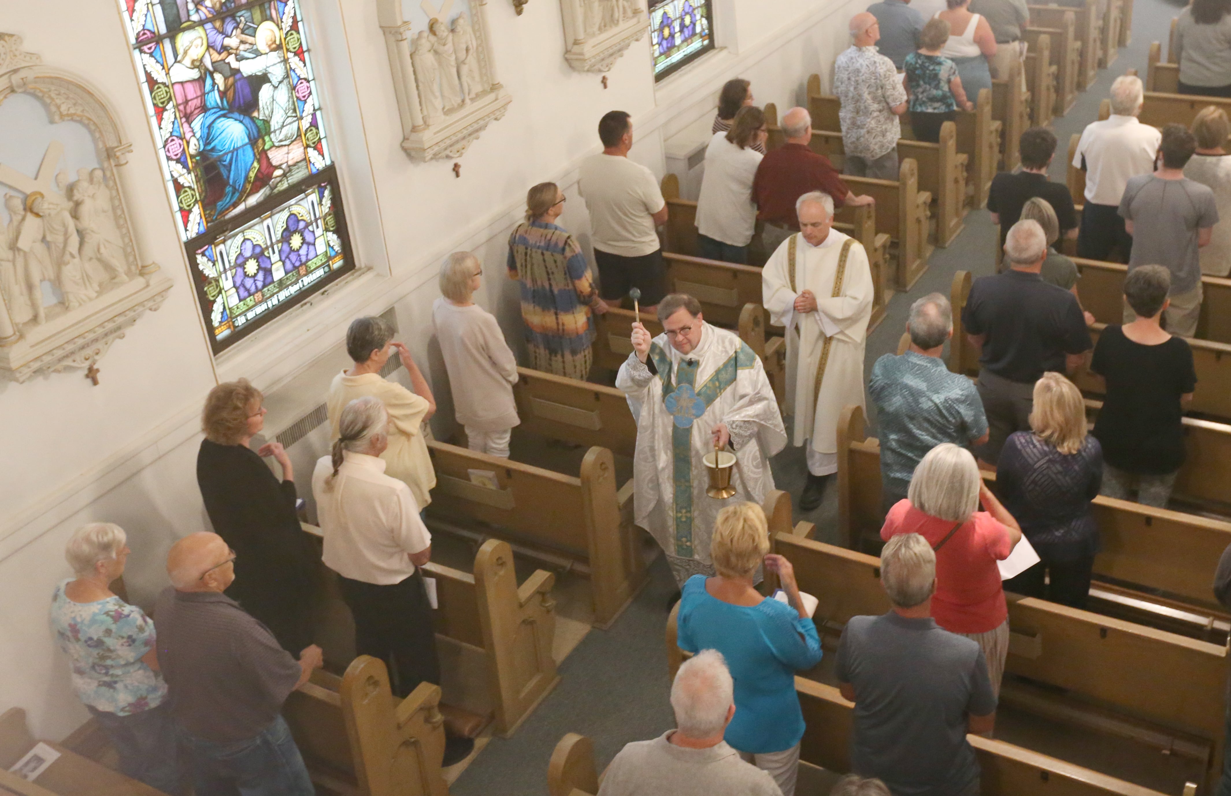 Fr. Gary Blake blesses parishioners with Holy Water during the final Mass at St. Mary's Church on Thursday, Aug. 15, 2024 in Peru. The church was founded in 1867.