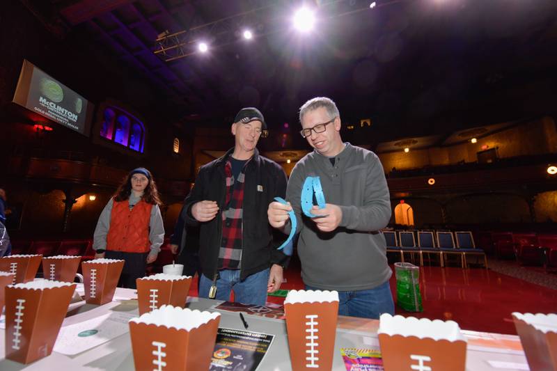 Jim Discher and Steven Mastel enter a raffle during the Arcada Theatre’s “Mongo Bowl 23” to raise money for former Chicago Bears player Steve “Mongo” McMichael, who has ALS, on Sunday, Feb. 12, 2023.