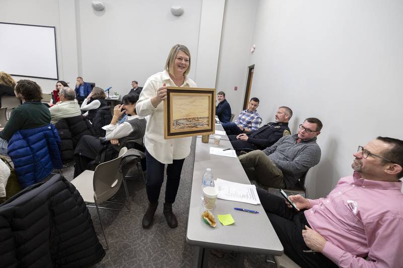 The Next Picture Show executive director Letha Catalina shows off a small replica of the earliest known painting of the Rock River Monday, Dec. 18, 2023. The gallery is selling prints as a fundraiser and has gifted a larger version to the city.