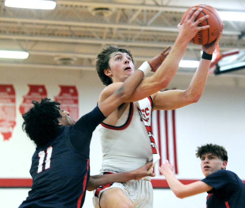 Yorkville's Bryce Salek puts in a shot and gets fouled by West Aurora defender Jordan Brooks (11) during a class 4A regional semifinal basketball game at Yorkville High School on Wednesday, Feb. 21, 2024.